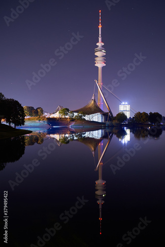 Munich skyline at night reflecting in a lake in the Olympiapark. photo