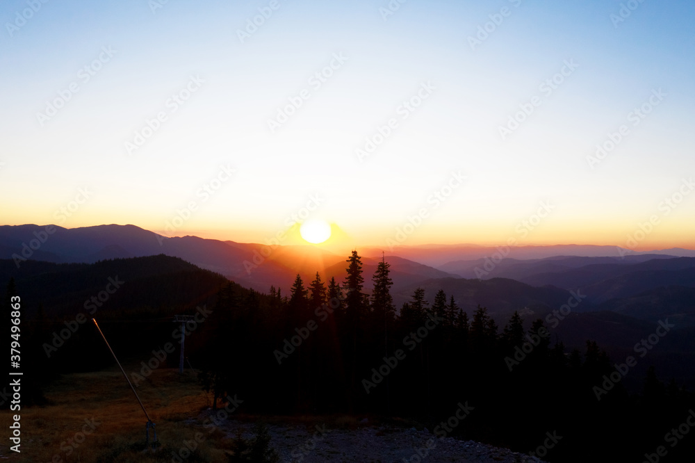 Beautiful mountain landscape in the rays of the setting sun. Background sunset / sunrise with clouds, light rays and other atmospheric effect. Wonderful mountains landscape Bansko, Bulgaria, Europa.