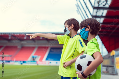 Two boys wanting to play football in stadium during covid-19