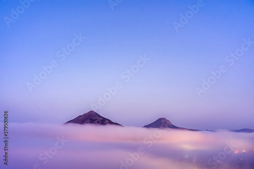 Pink Layer of Clouds with Mountain Peaks Above the Fog