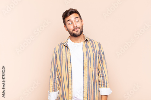 young man wondering, thinking happy thoughts and ideas, daydreaming, looking to copy space on side photo