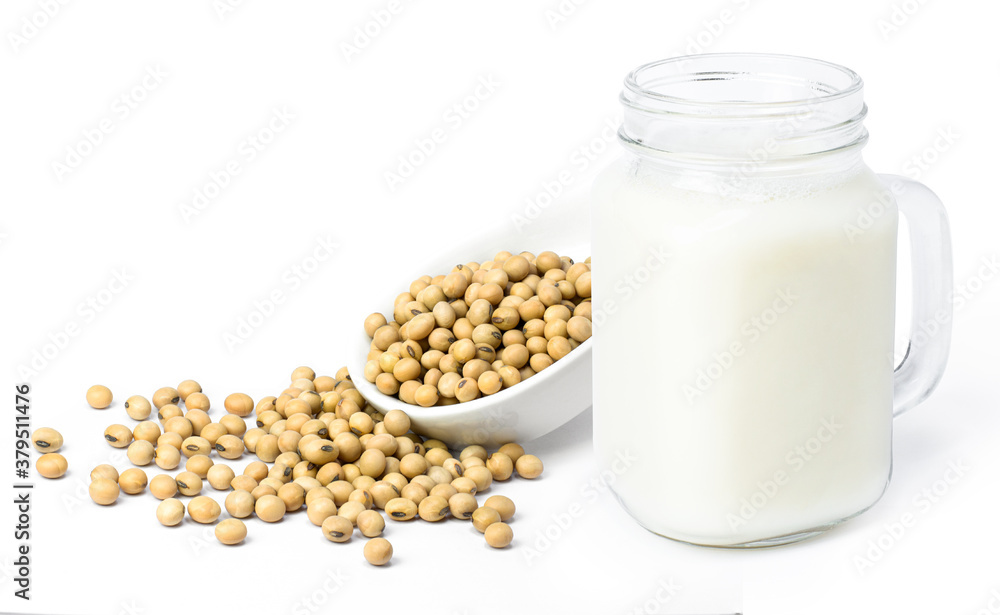 Soy milk in glass pitcher jug and soybeans in ceramic spoon isolated on white background. Soy milk in glass pitcher jug and soybeans in ceramic spoon isolated on white background.