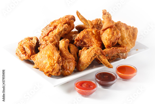 Fotografie Platter of family sized fried chicken with three sauces on white background with