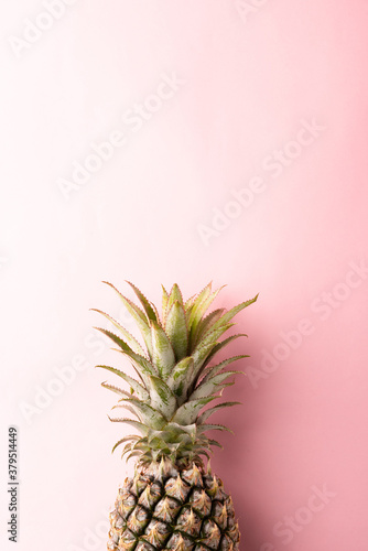 Close up above top view of ripe pineapple fruit on pink pastel background, Summer Tropical concept
