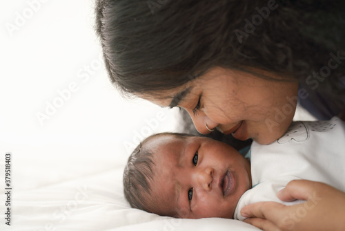 mixed race african american and asian mother gentle kiss newborn baby