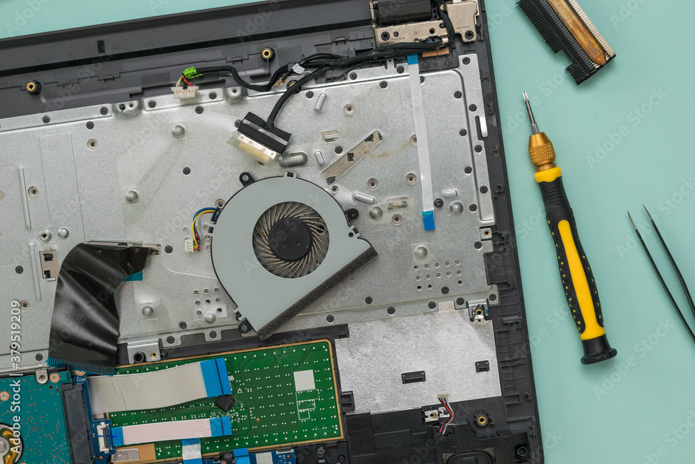 CPU cooling fan and disassembled laptop on a blue background. CPU cooling fan and disassembled laptop on a blue background.