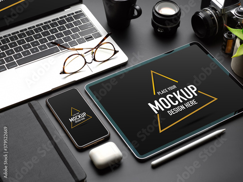 Mock up digital devices with tablet, smartphone and laptop on black table