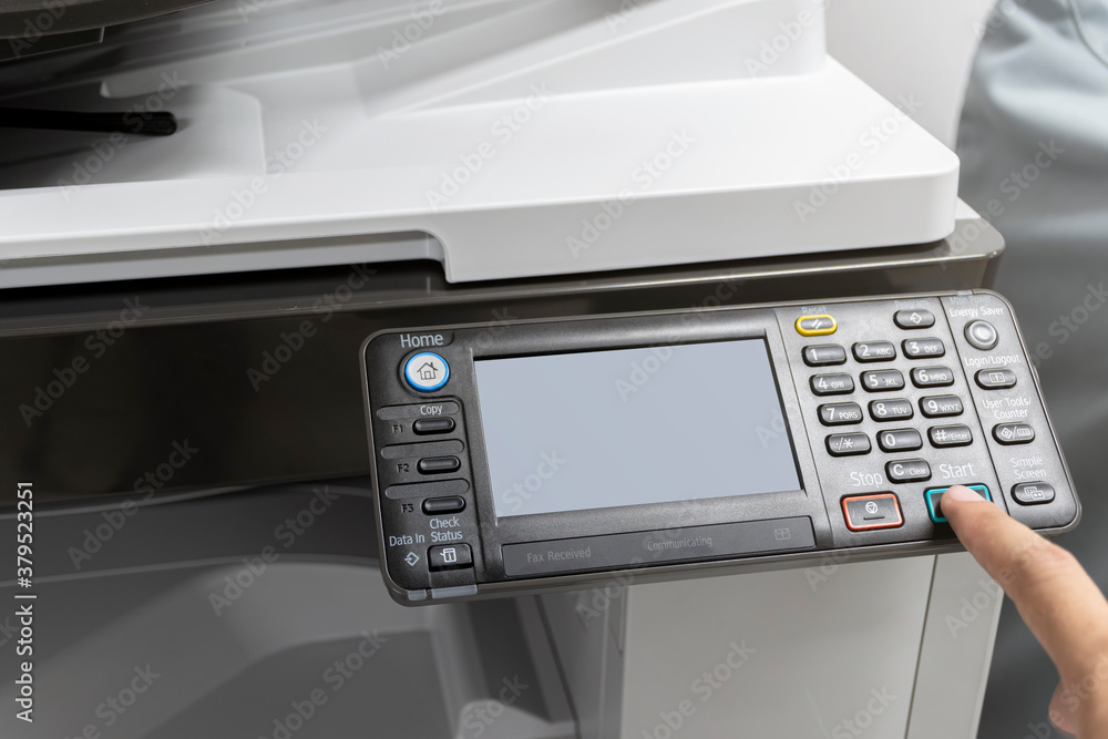 Man pressing a button to start a copy machine Man pressing a button to start a copy machine