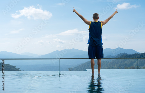 Young guy stand on swimming pool