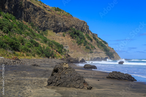 The black sand beach at Maukatia Bay in the western Auckland Region, New Zealand. Lumps of 