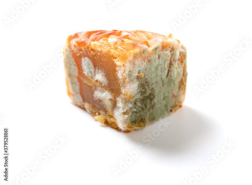 piece of cut out moldy moon cake on white background