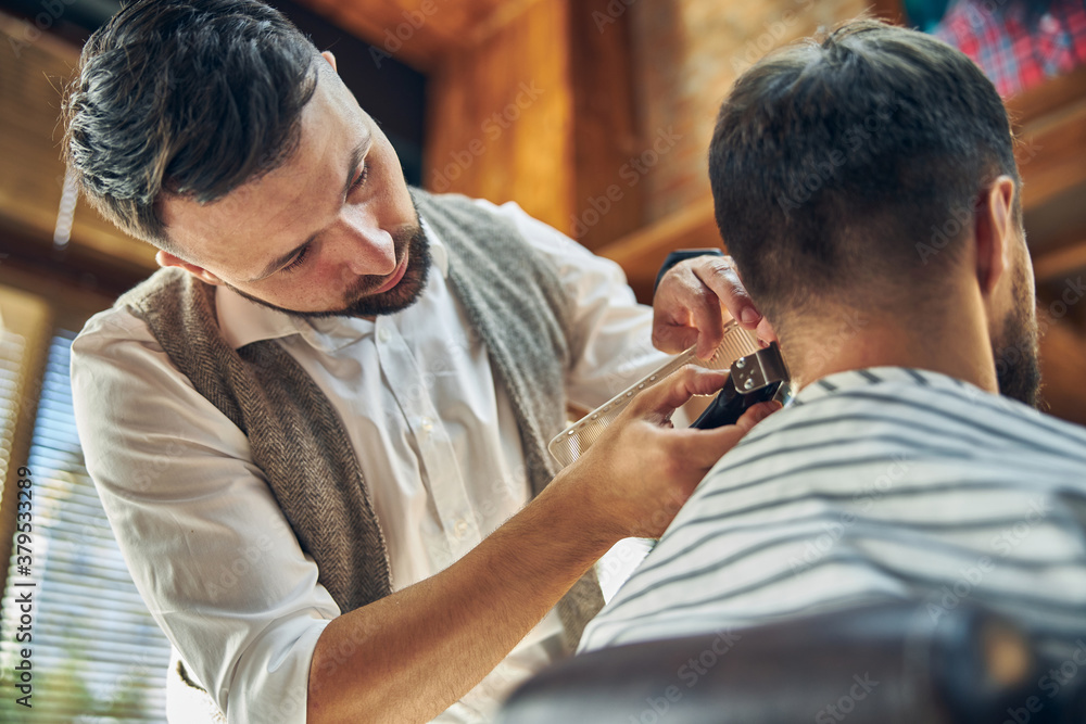 Fototapeta premium Professional barber taking a look at client hair