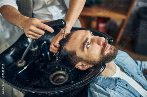 Hairstylist washing his client hair at a barbershop