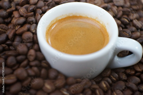 Soft focus a cup of espresso coffee and coffee beans on Wooden table background. 