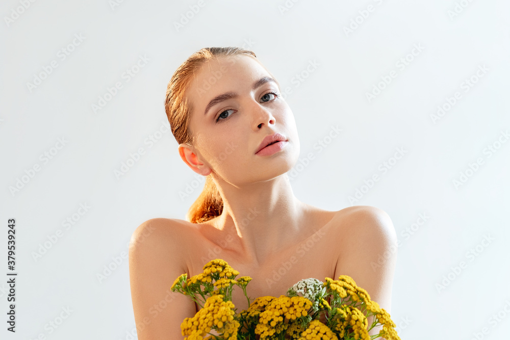 Natural cosmetology. Herbal therapy. Portrait of woman with perfect skin nude makeup bare shoulders wild flowers isolated on light white copy space background. Beauty wellness. Ayurveda dermatology.