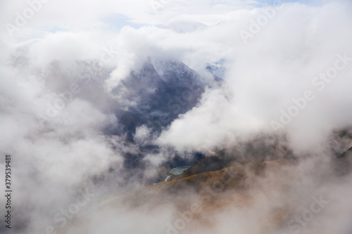 Alpine landscape. Photo of clouds from a high mountain. Soft focus. Clouds float between the mountains.