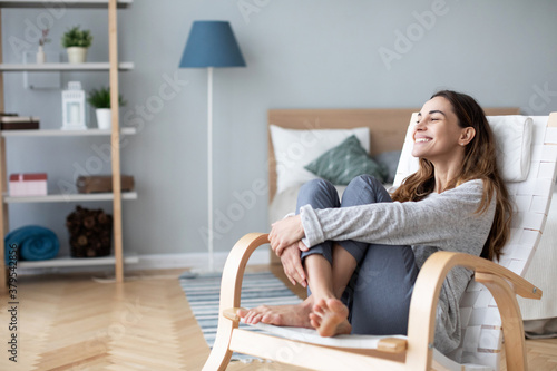 Woman relaxing in cozy chair at home. Female portrait. photo