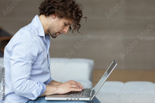 Young man freelancer working at home on laptop.
