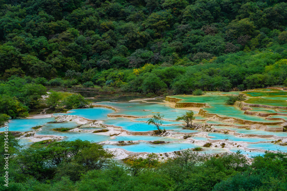 The turquoise color hot spring pools in Huanglong Valley, Sichuan, China, on summer time.