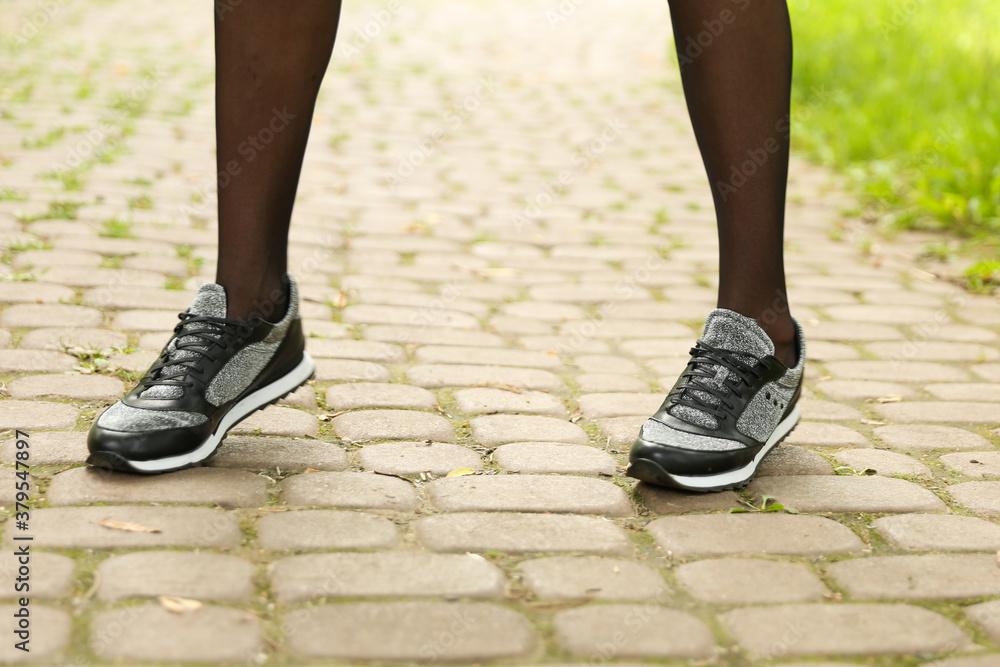 woman's legs wearing sporty sneakers outdoor close up woman's legs wearing sporty sneakers outdoor close up