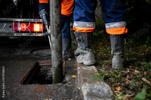 Cleaning storm drains from debris, clogged drainage systems are cleaned with a pump and water photo