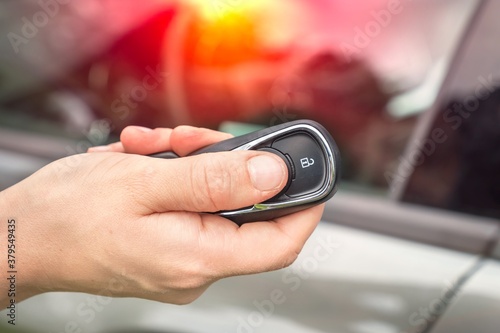 Woman lock or unlock her car with car remote control photo