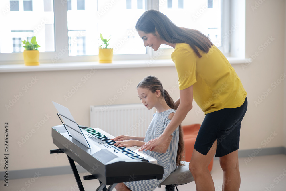 Girl having a private music lesson and looking concentrated Girl having a private music lesson and looking concentrated