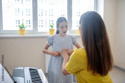 Girl and her music teacher talking and looking involved photo
