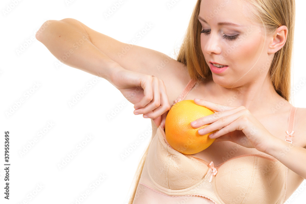 Woman small boobs puts big fruit in her bra Stock Photo