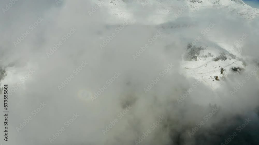 Aerial view of misty winter sunrise in the Swiss Alps mountains. Aletsch arena, Switzerland. Flying through the clouds Aerial view of misty winter sunrise in the Swiss Alps mountains. Aletsch arena, Switzerland. Flying through the clouds