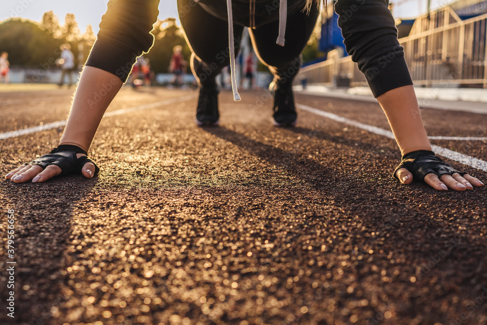 Young athletic woman doing plank exercise on running track. Sunset light on background, beautiful perspective. photo without face. Young athletic woman doing plank exercise on running track. Sunset light on background, beautiful perspective. photo without face.