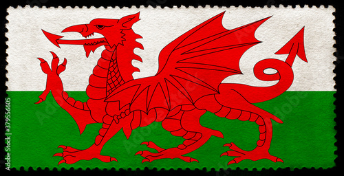 Welsh flag on the old grunge postage stamp isolated on black background
