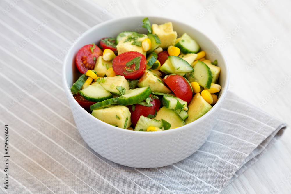 Fresh Avocado Tomato Salad in a bowl, low angle view.