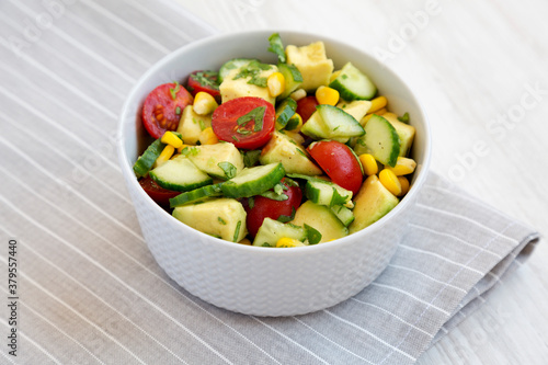 Fresh Avocado Tomato Salad in a bowl, low angle view.
