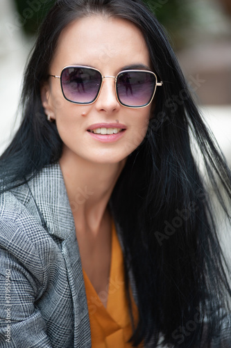 Beautiful dark-haired European girl in the city in sunglasses