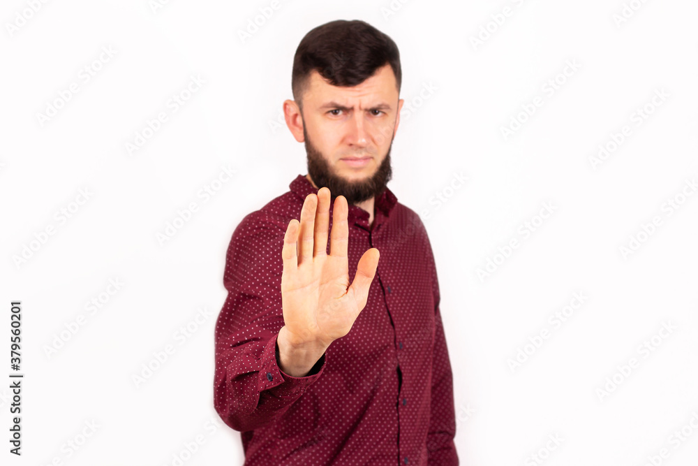 Young man over isolated background doing stop sing with palm of the hand. Warning expression with serious gesture on the face. Studio Young man over isolated background doing stop sing with palm of the hand. Warning expression with serious gesture on the face. Studio