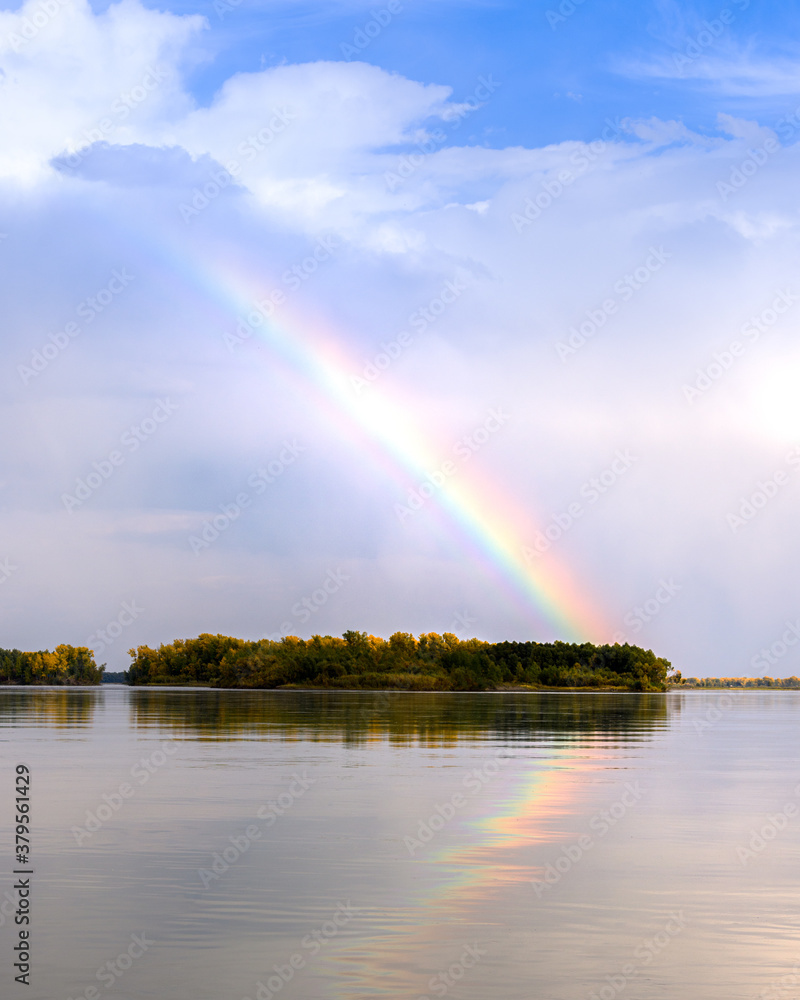 landscape on the river with a rainbow in the blue sky, the edge of the Bank with an autumn forest landscape on the river with a rainbow in the blue sky, the edge of the Bank with an autumn forest