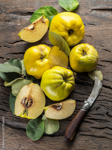 Ripe golden yellow quince fruits on wood. Organic fruits on old table. Top view. photo