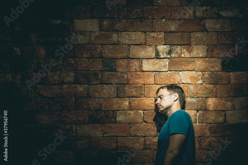 Left side view man under life crisis problems stand wearily leaned head against brown brick wall, closed eyes tired sign, wants to climb, overcome obstacle, reach a goal, leader, motivation