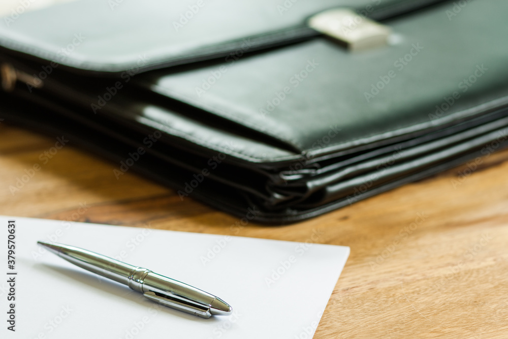 Aktentasche, Papier und Stift auf Schreibtisch Aktentasche, Papier und Stift auf Schreibtisch