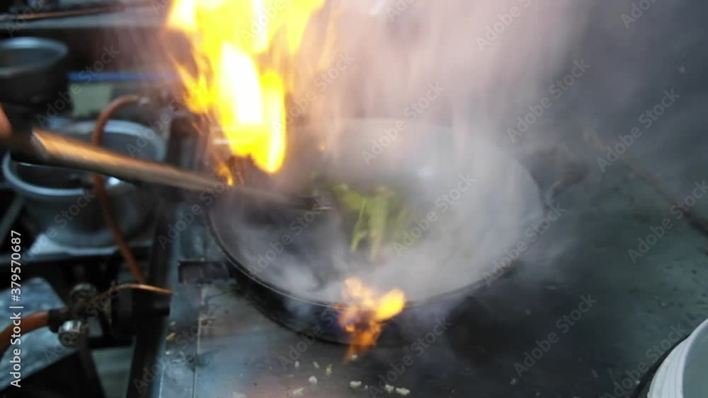 Close up Chef preparing cooking food Stir fried water mimosa with chillis pepper and fires up in hot frying pan at kitchen restaurant, Thai traditional food . Close up Chef preparing cooking food Stir fried water mimosa with chillis pepper and fires up in hot frying pan at kitchen restaurant, Thai traditional food .