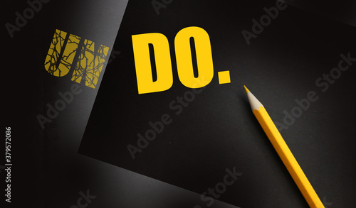 Fotografija Close up of a yellow pencil and the wordsUno transformed to Do on black paper