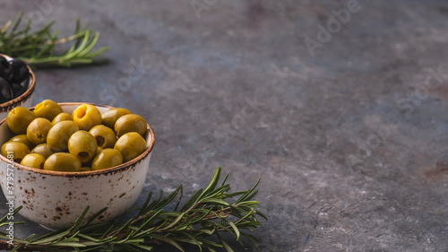 Olives in a bowl with rosemary. Copy space