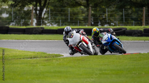 A shot of two racing bikes cornering as they circuit a track.