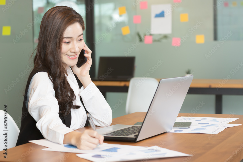 Asian business woman use labtop and note job on paper in office. Asian business woman use labtop and note job on paper in office.