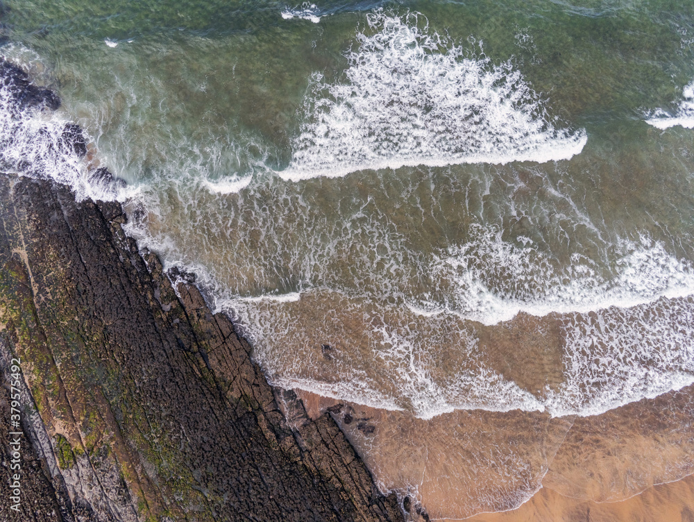 Aerial drone view on Fanore beach, county Clare, Ireland. Beautiful powerful ocean waves and stone coast line, top down view