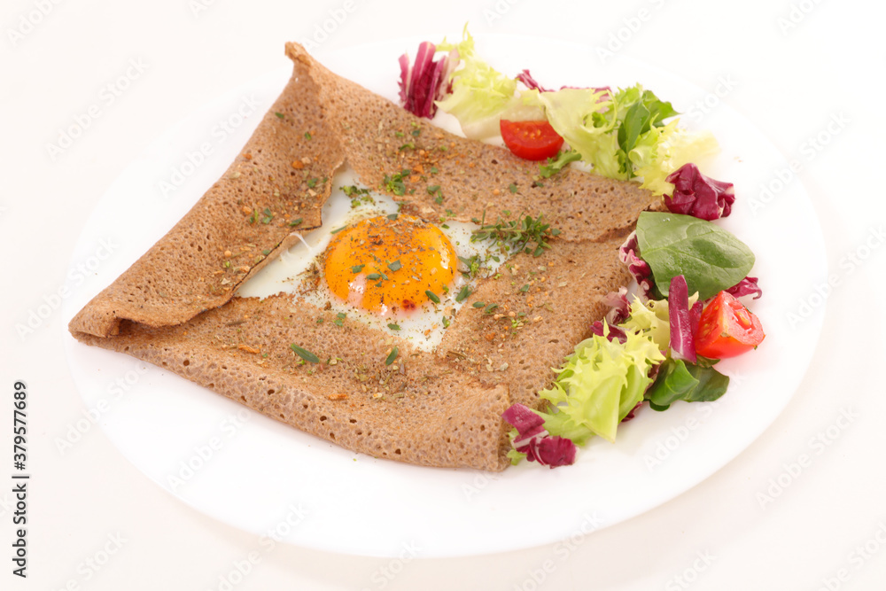 crepe with egg and lettuce on white background crepe with egg and lettuce on white background