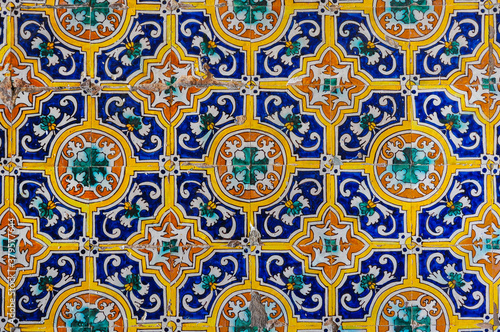 Ceramic tiles (azulejos) with floral patterns on a wall of the Alcazar of Seville, Spain