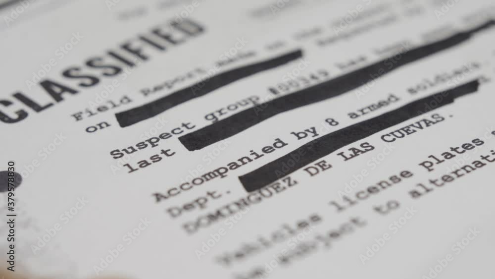 Close up. Hand erases sensitive text with black marker for censorship purpose. Classified