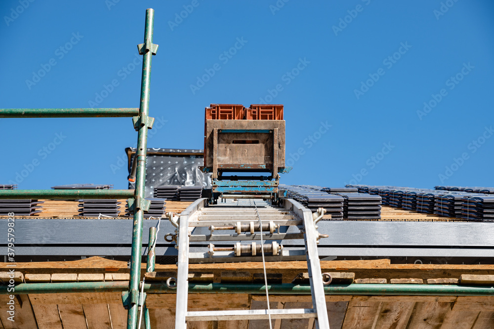 Naklejka premium laying tiles on the roof of a single-family house